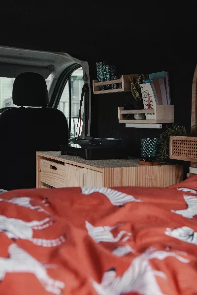 L'intérieur d'un van aménagé avec des étagères et des livres.
